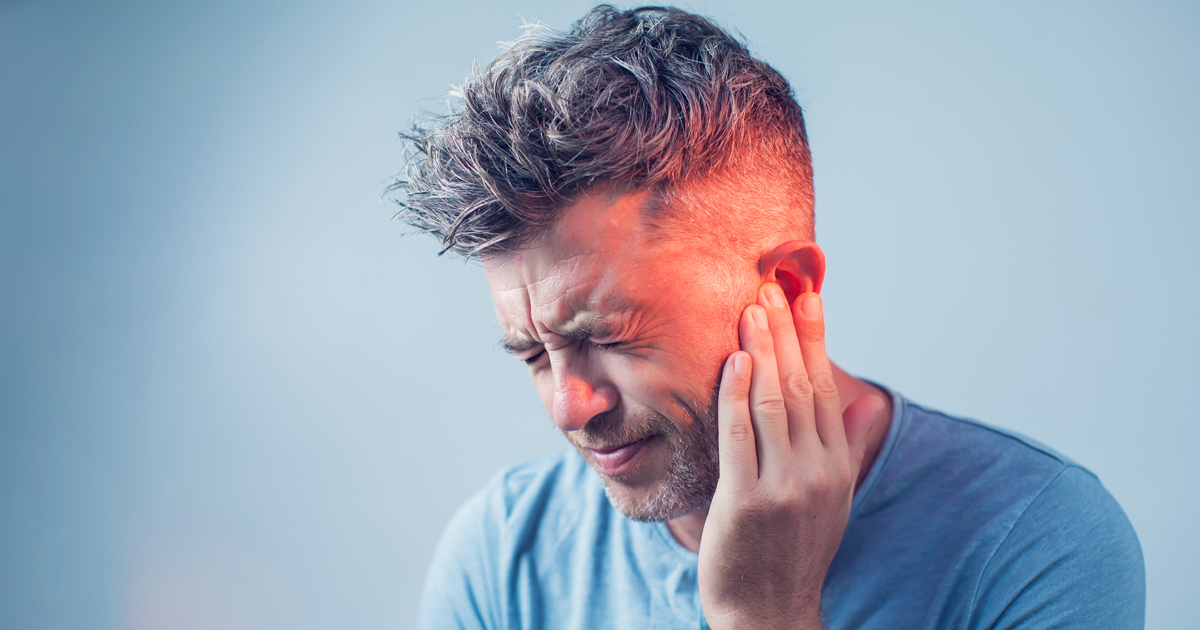 Man grabbing his ear in pain