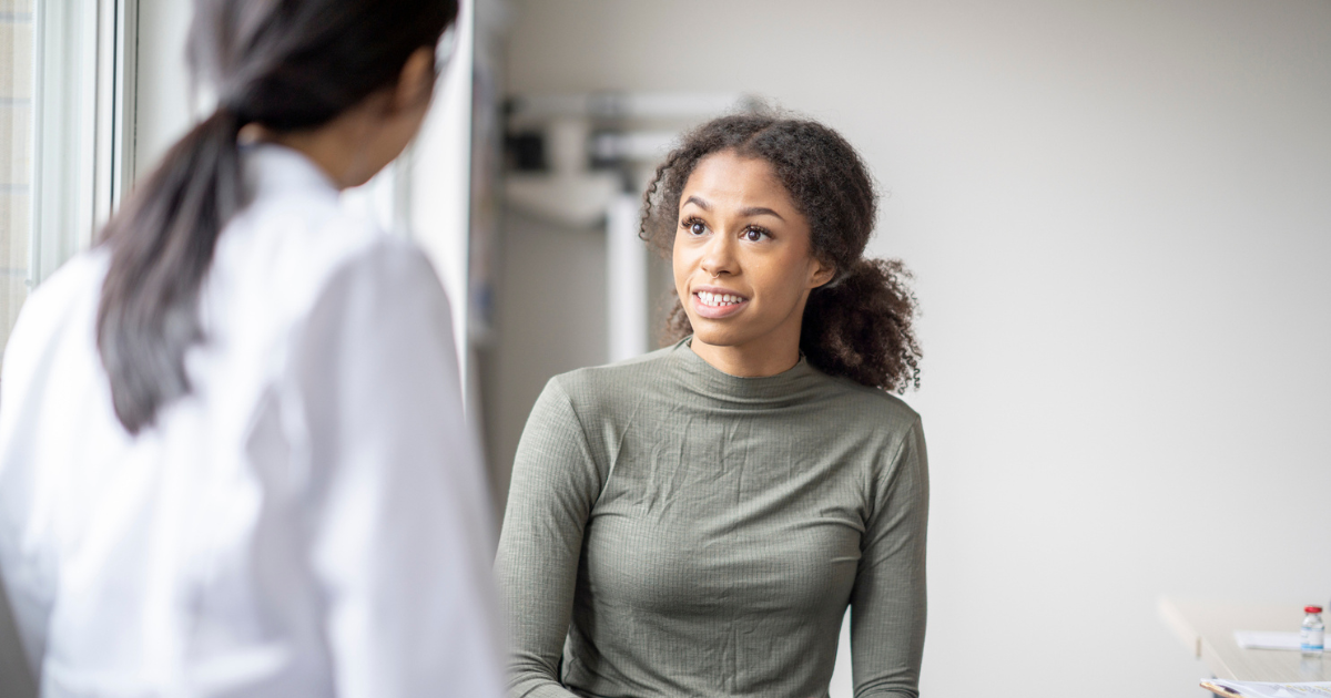 Young woman talking to her doctor