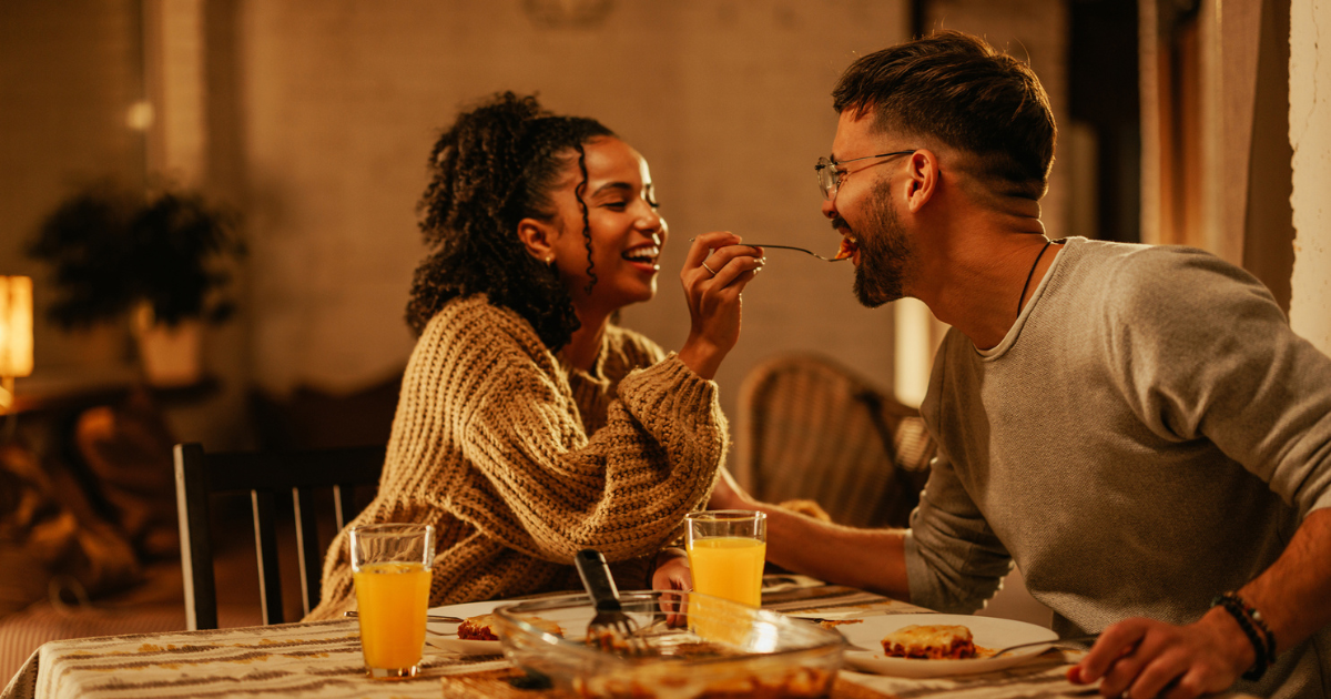 Young woman feeding her boyfriend