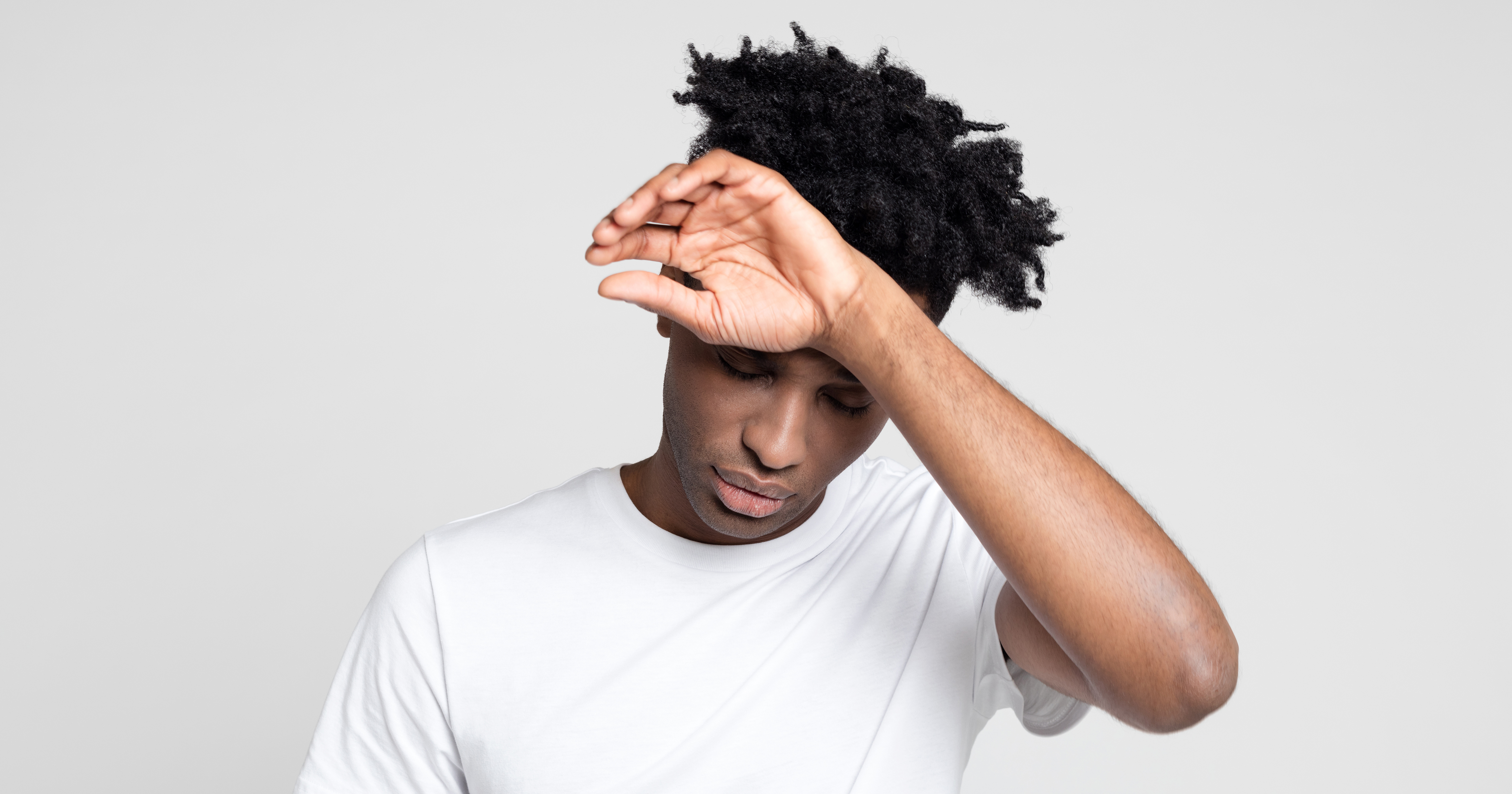 Teenager touching his forehead.