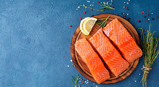 Three pieces of pink salmon on a blue plate. 