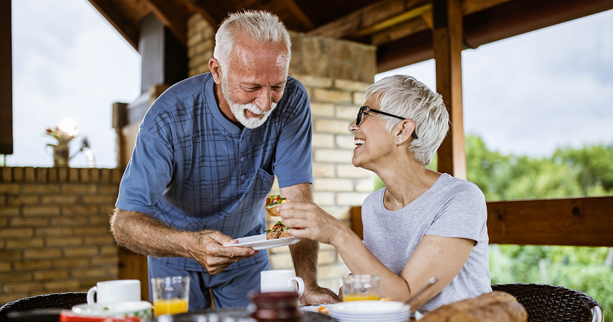 Older couple eating a meal outside