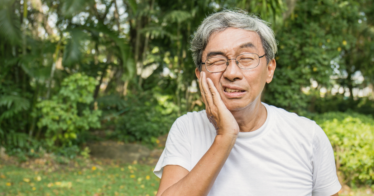 Man holding his mouth in pain