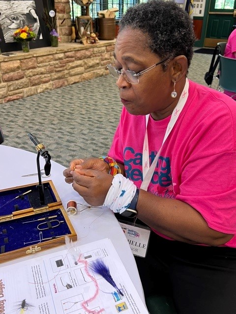 Woman making a fly fishing lure.