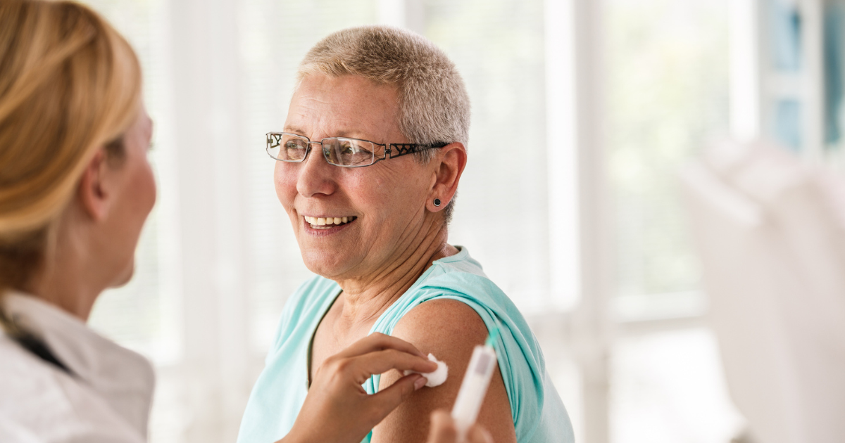 Doctor sanitizing a woman's arm before a vaccination