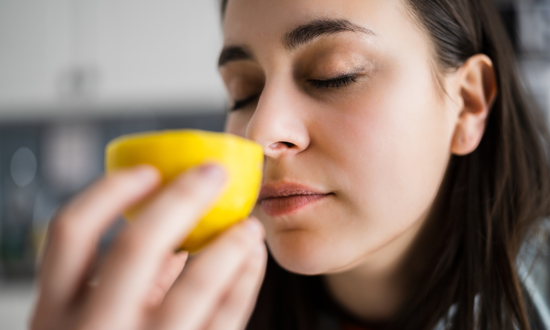 picture of a woman smelling a lemon