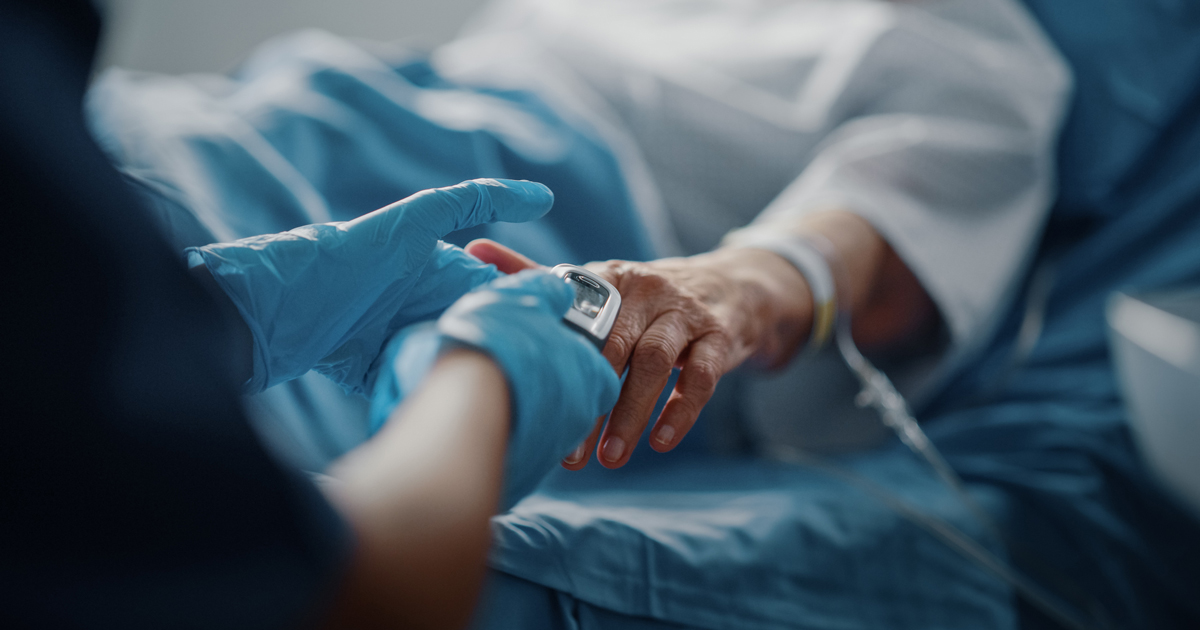 Medical provider in a gloved hand holding another hand