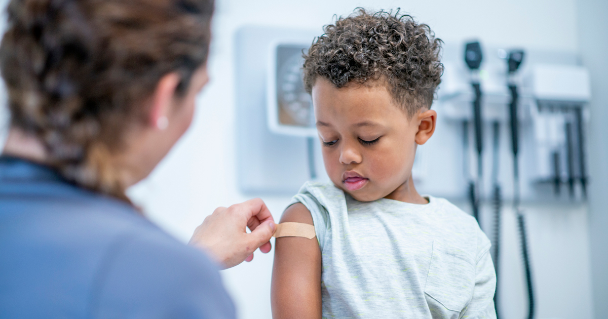 Young boy getting bandaid after shot