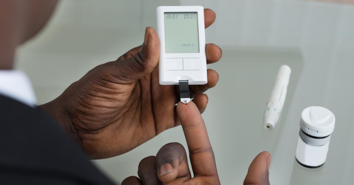 Man sitting at table holding glucose meter