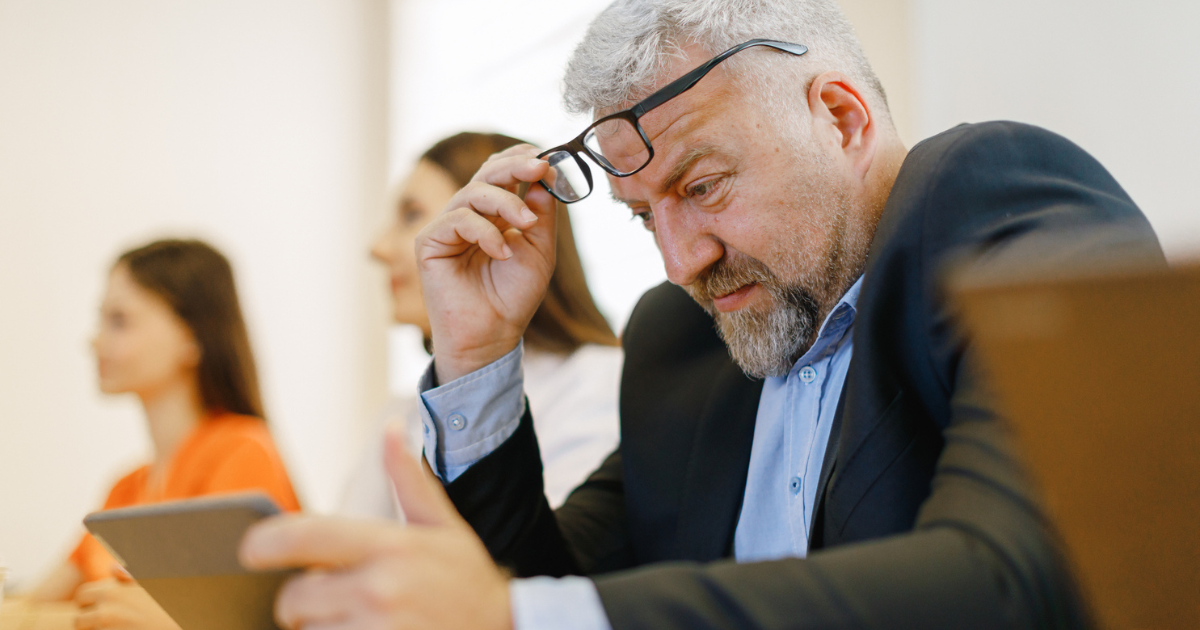 Man squinting at his tablet