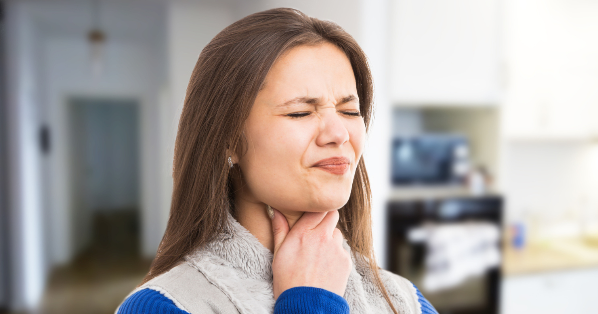 Woman grabbing her throat in pain