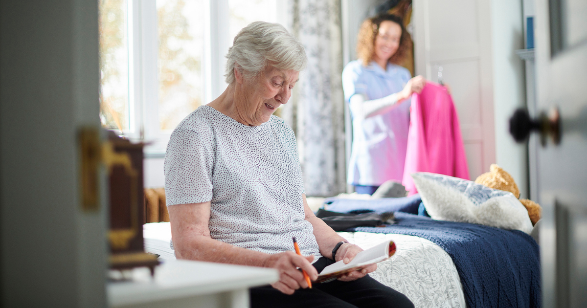 Elderly woman sitting on her bed