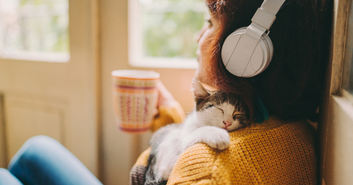 Woman drinking coffee wearing headphones