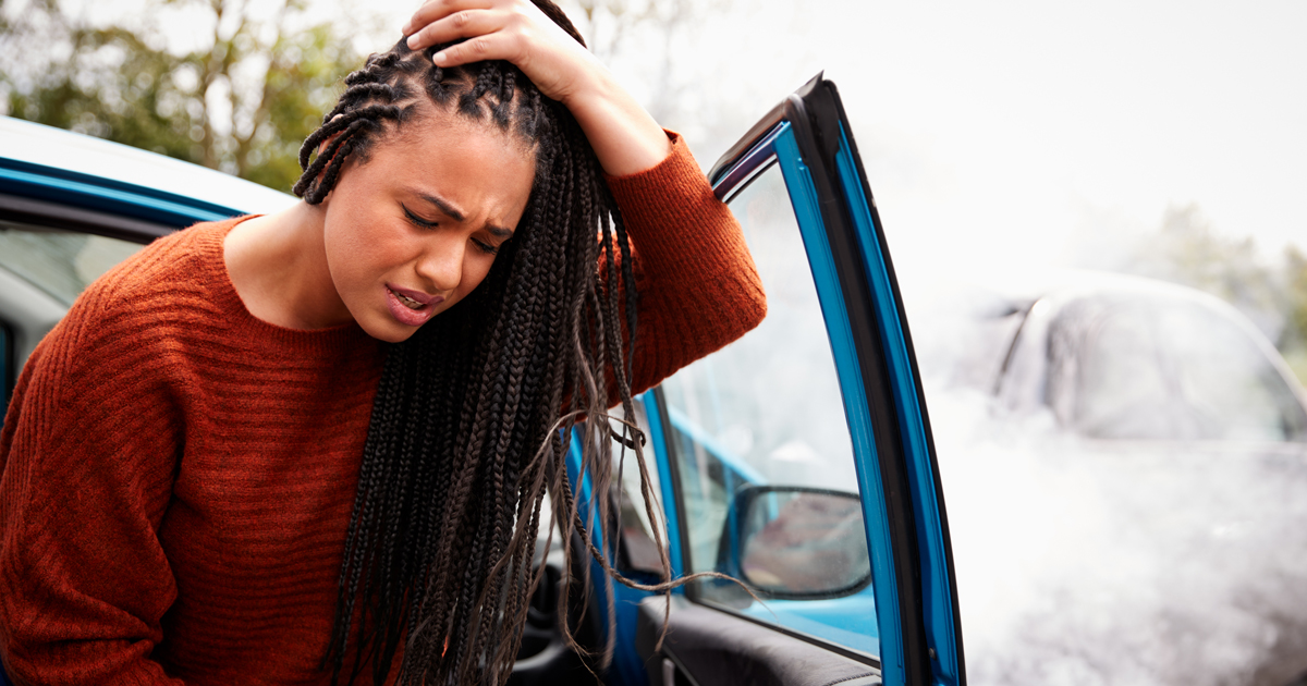 woman holding head after car crash