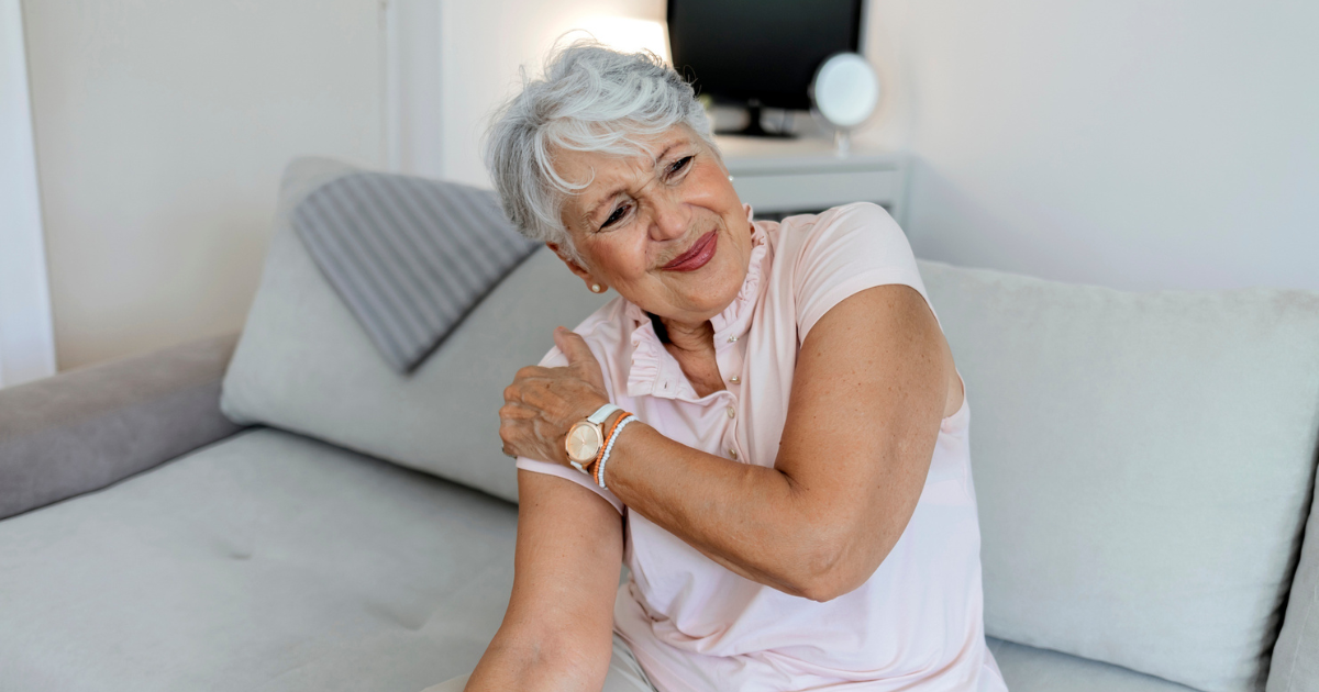 Older woman grabbing her shoulder in pain