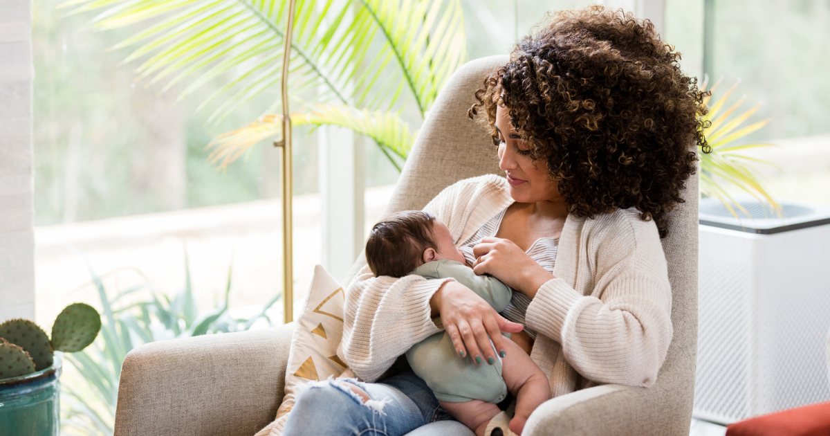 Woman sitting in a rocking chair breastfeeding her baby