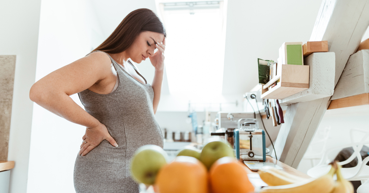 Sad pregnant woman in the kitchen