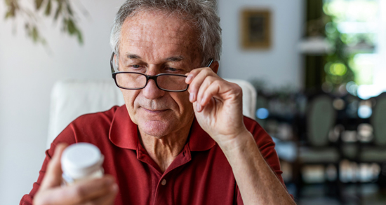 picture of a man looking at a pill bottle