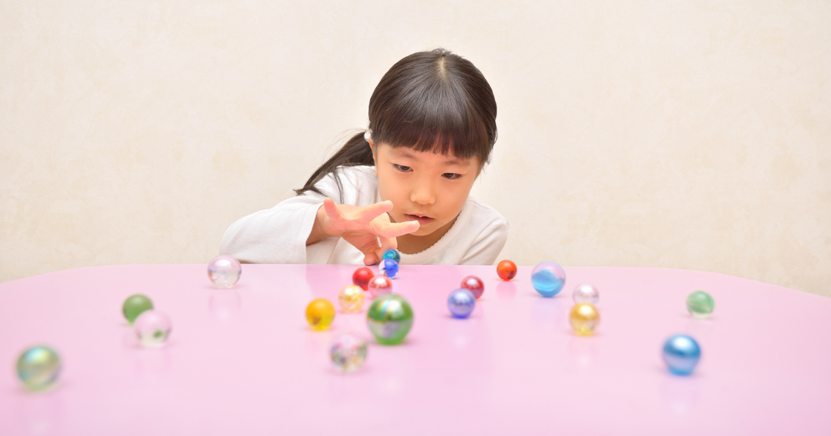 Young girl playing marbles