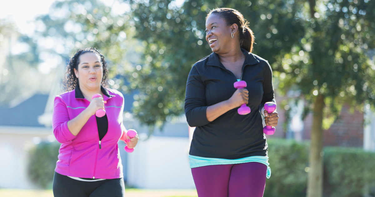 Two women running holding weights