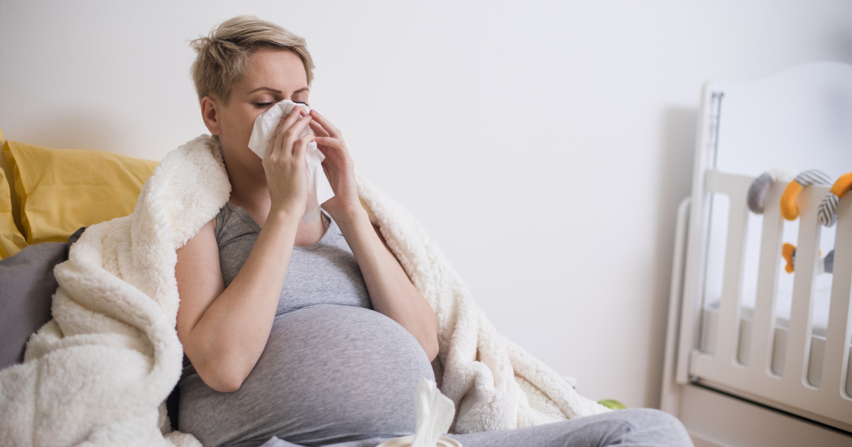 Pregnant woman blowing her nose