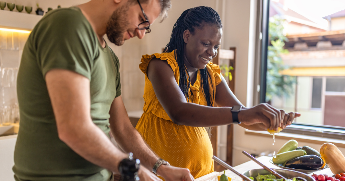 Pregnant woman and her partner making a meal