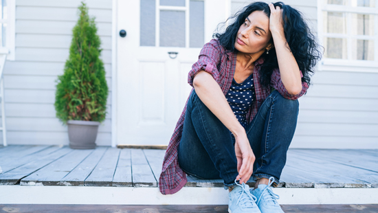 picture of a woman sitting in front of her home