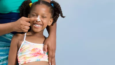 picture of a woman applying sunscreen to a child