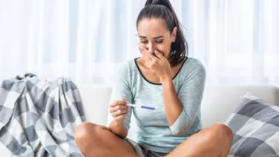 picture of a woman looking at a pregnancy test