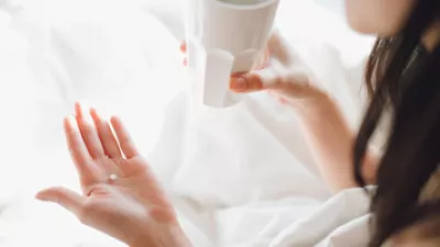 picture of a woman about to take a pill