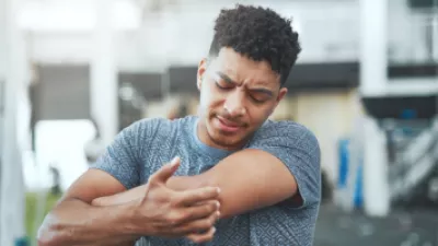 Man at the gym grabbing his elbow