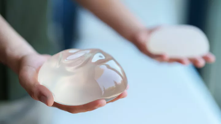 Hands holding saline breast implants