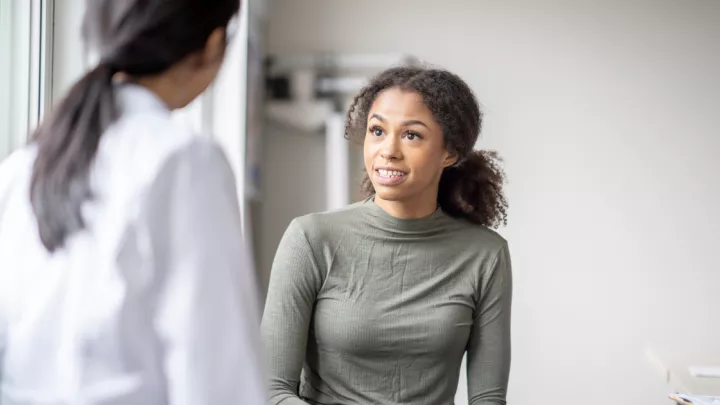 Young woman talking to her doctor