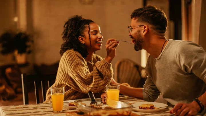 Young woman feeding her boyfriend