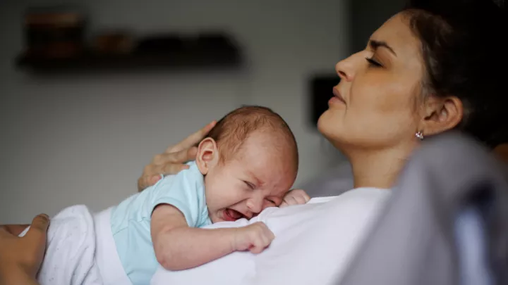 Tired mother holding her baby