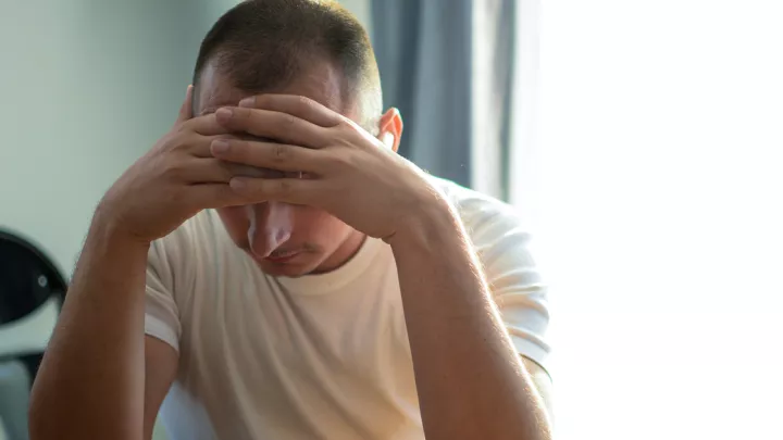 Man holding his head in his hands