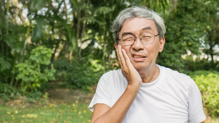 Man holding his mouth in pain