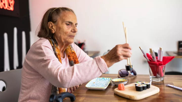 Older woman eating sushi