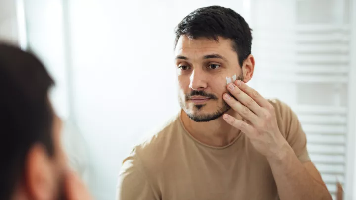 Man putting moisturizer on his face