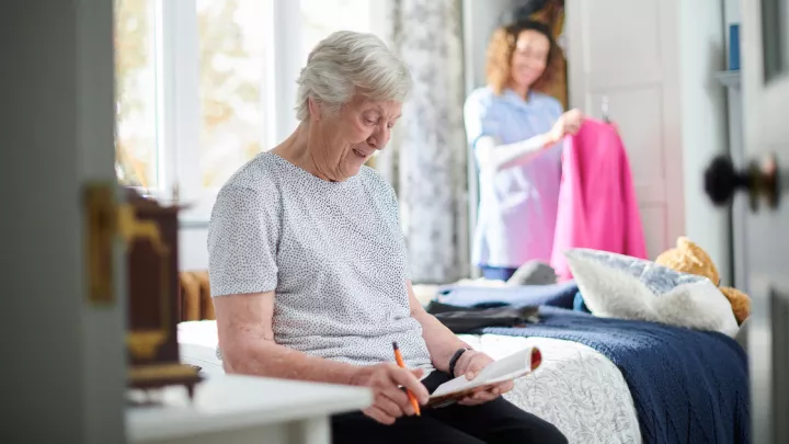 Elderly woman sitting on her bed
