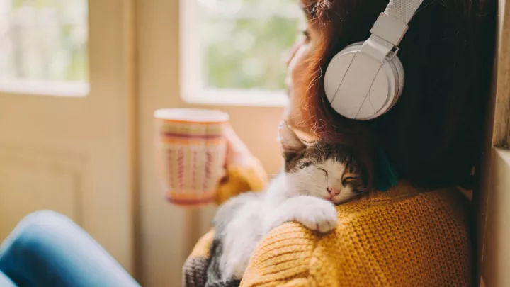 Woman drinking coffee wearing headphones