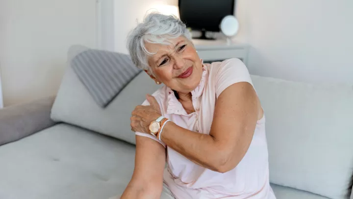 Older woman grabbing her shoulder in pain