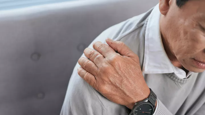picture of a man holding his shoulder