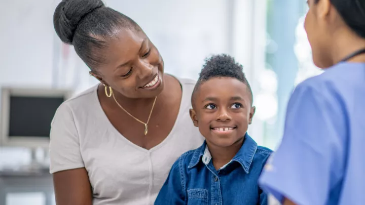 Mother and young son talking to provider in doctor's office