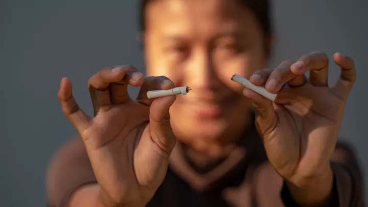 Woman breaking cigarette in half