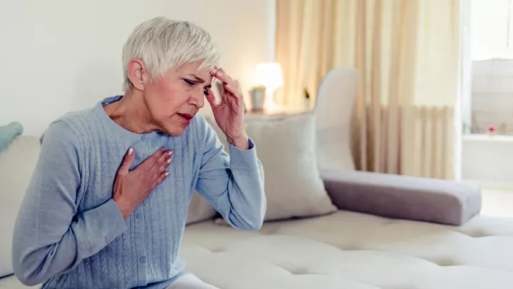Older woman holding her heart and head