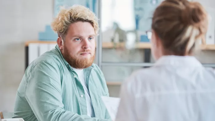 Man sitting, speaking to his doctor