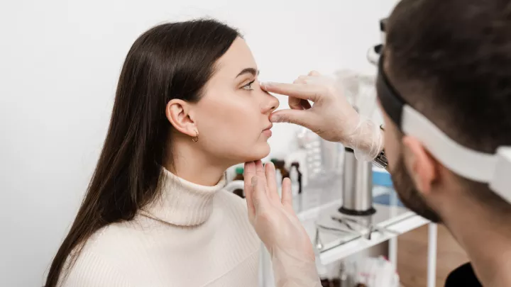 Doctor evaluating a woman's nose for a rhinoplasty