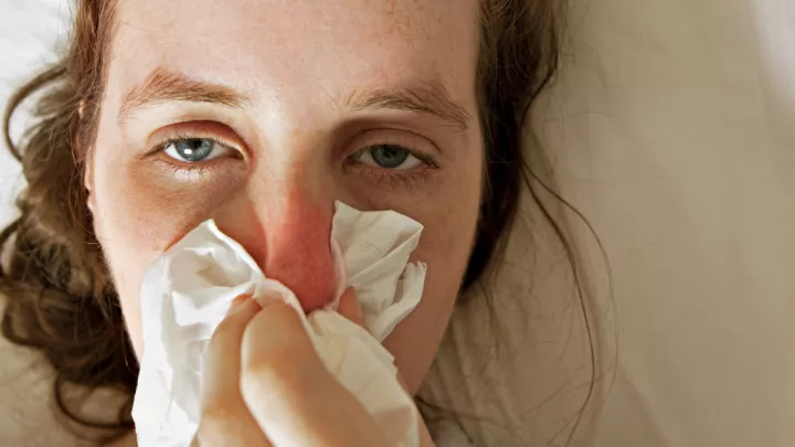 Woman blowing her nose