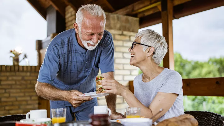 Older couple eating a meal outside